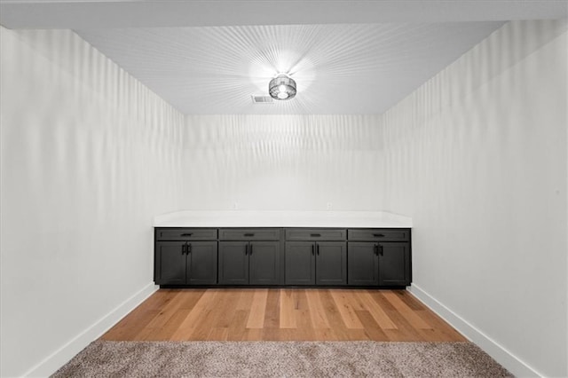 interior space with baseboards and light carpet
