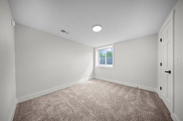 spare room with carpet floors, baseboards, and visible vents