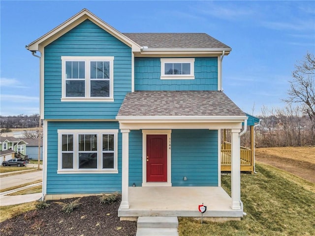 view of front of home with a front yard and roof with shingles