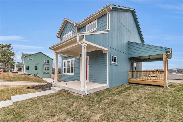 rear view of property featuring a lawn and a patio area