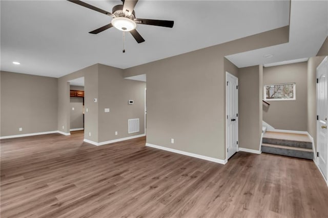 unfurnished living room featuring a ceiling fan, wood finished floors, baseboards, and visible vents