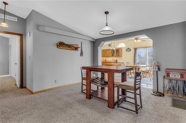 dining room featuring vaulted ceiling, visible vents, a ceiling fan, arched walkways, and light colored carpet