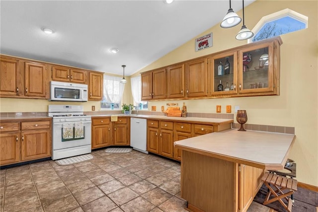 kitchen featuring a peninsula, lofted ceiling, white appliances, pendant lighting, and light countertops