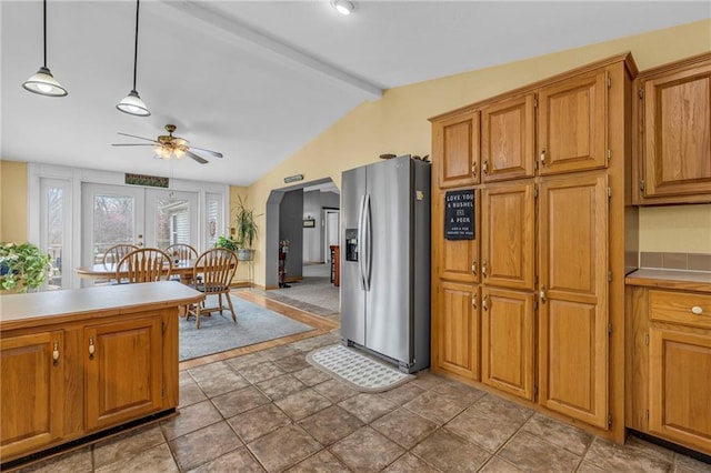 kitchen with vaulted ceiling with beams, brown cabinets, ceiling fan, stainless steel fridge with ice dispenser, and light countertops