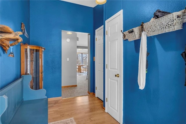 hallway featuring baseboards and wood finished floors