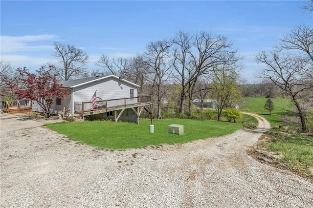 view of yard with a wooden deck and driveway