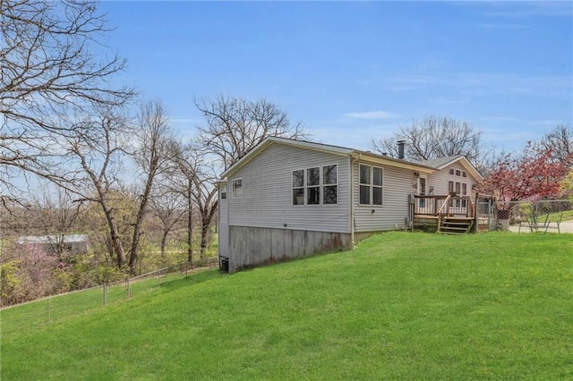 rear view of property with fence, a yard, and a deck
