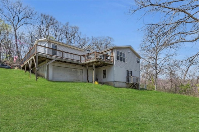 rear view of property with a wooden deck, a lawn, a garage, and driveway