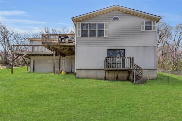 rear view of property with a wooden deck, a lawn, fence, and driveway
