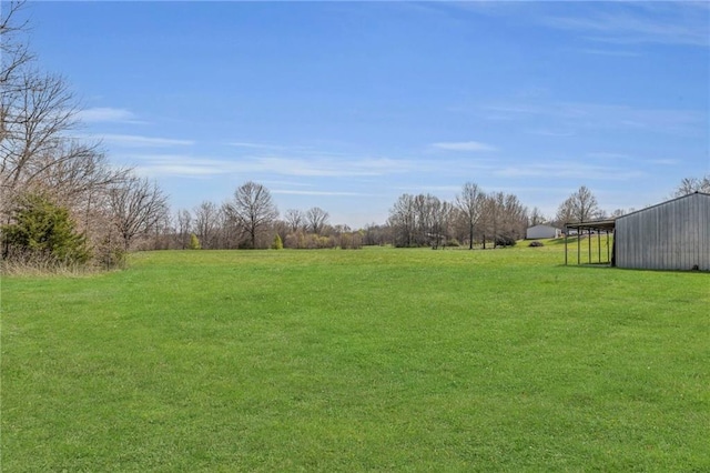 view of yard featuring an outdoor structure, an outbuilding, and a rural view