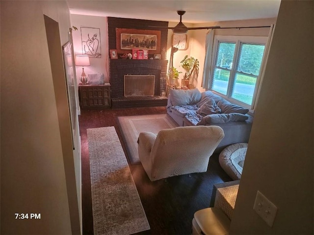 living area with a brick fireplace and wood finished floors