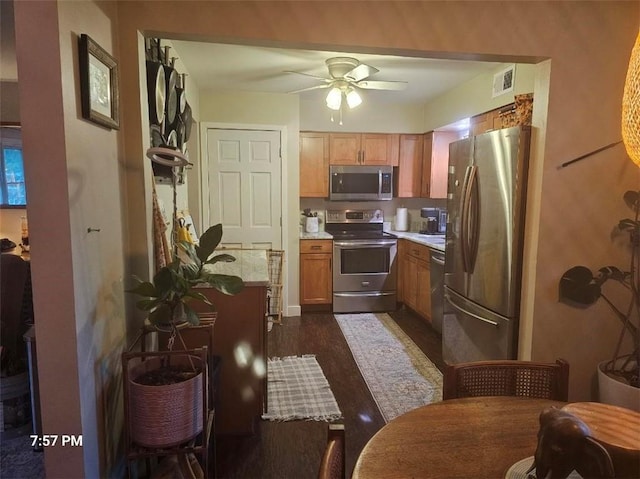 kitchen with appliances with stainless steel finishes, ceiling fan, and dark wood finished floors