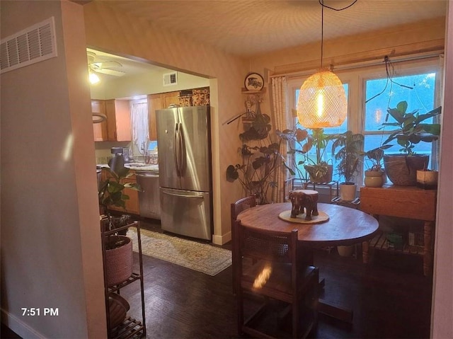 dining room featuring dark wood finished floors, baseboards, and a ceiling fan