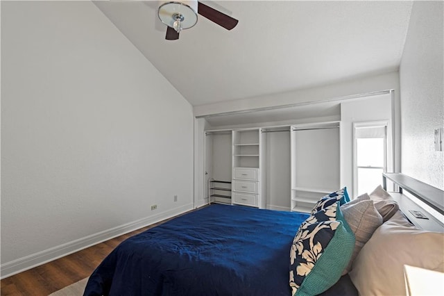 bedroom with ceiling fan, baseboards, wood finished floors, vaulted ceiling, and a closet