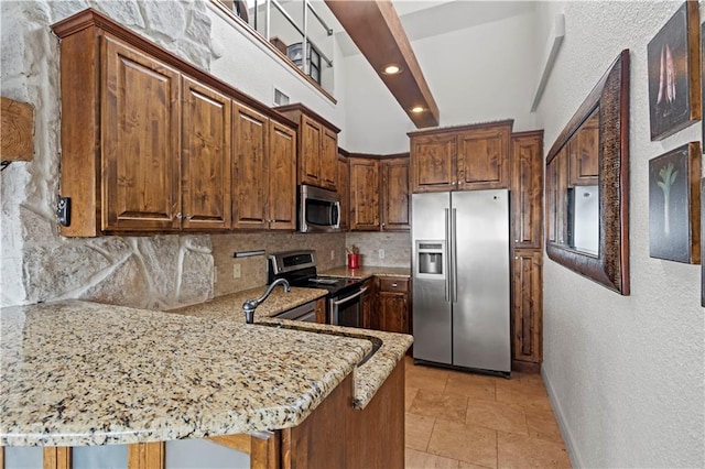 kitchen featuring light stone countertops, stainless steel appliances, recessed lighting, a peninsula, and tasteful backsplash