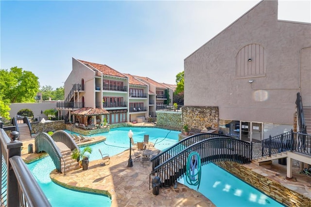 community pool featuring stairway and a patio