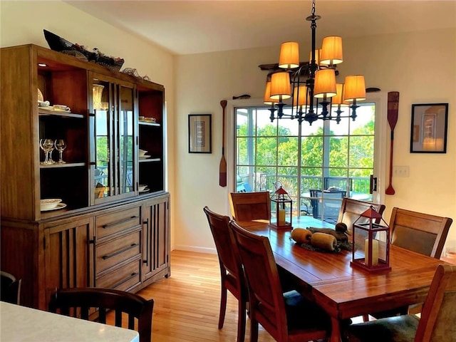 528 W End Cir, Osage Beach, MO 65065 - dining space with a chandelier, light wood-type flooring, and baseboards