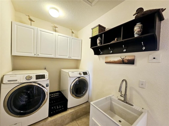 528 W End Cir, Osage Beach, MO 65065 - clothes washing area featuring cabinet space, washing machine and dryer, a textured ceiling, and light tile patterned flooring