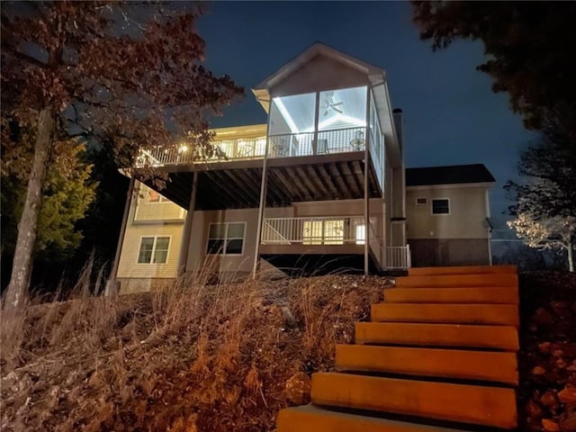 528 W End Cir, Osage Beach, MO 65065 - back of house at night with a wooden deck and stairway