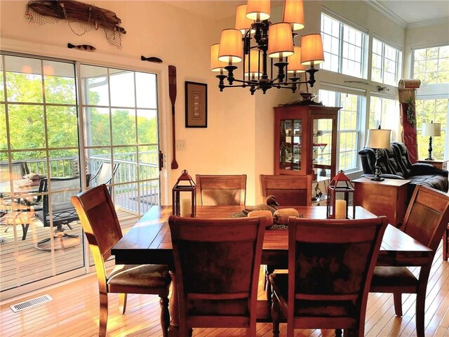 528 W End Cir, Osage Beach, MO 65065 - dining area with light wood-style flooring, crown molding, and a chandelier
