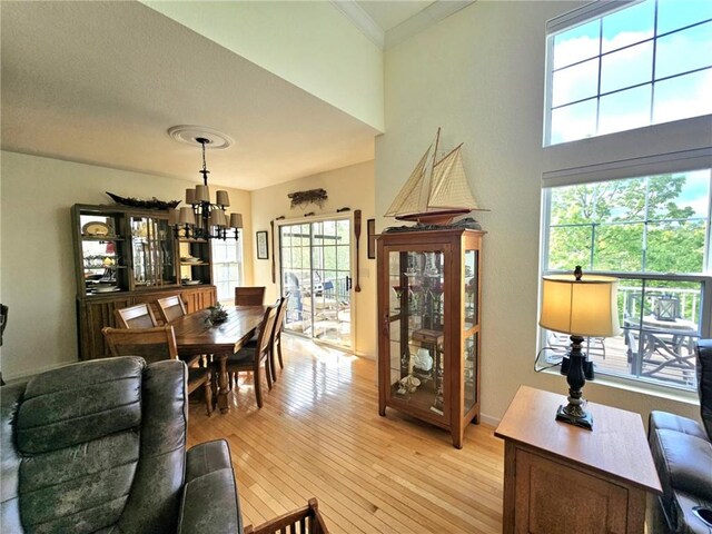 528 W End Cir, Osage Beach, MO 65065 - dining space with light wood-style flooring, ornamental molding, and a towering ceiling