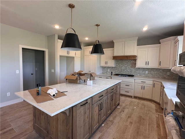 2005 Foxtail Pt, Kearney, MO 64060 - kitchen with stainless steel gas cooktop, light wood-style floors, backsplash, a spacious island, and recessed lighting