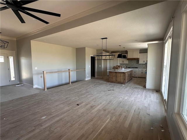 2005 Foxtail Pt, Kearney, MO 64060 - unfurnished living room featuring light wood-style floors, crown molding, and ceiling fan