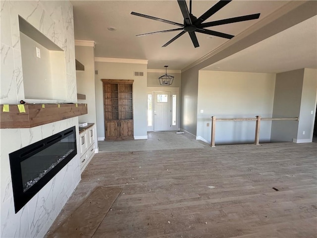 2005 Foxtail Pt, Kearney, MO 64060 - unfurnished living room featuring ornamental molding, wood finished floors, a glass covered fireplace, and a ceiling fan