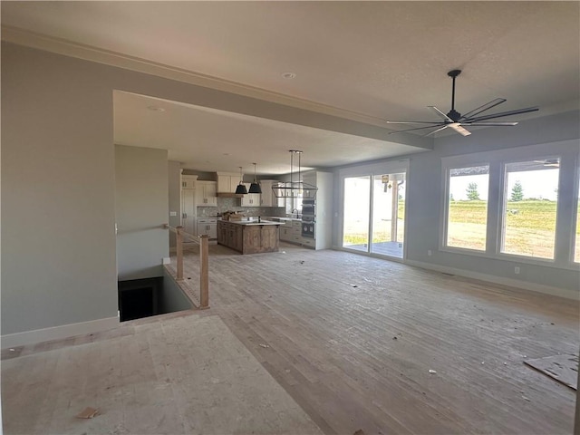 2005 Foxtail Pt, Kearney, MO 64060 - unfurnished living room featuring plenty of natural light, crown molding, light wood finished floors, and a ceiling fan