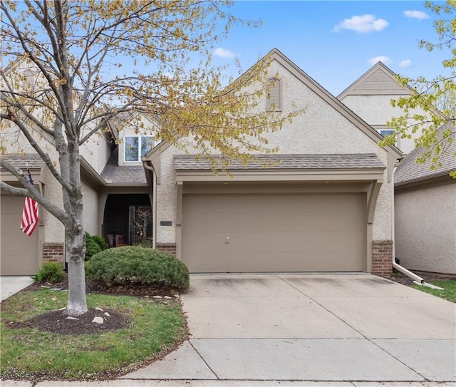 view of front of property with driveway, a garage, stucco siding, and brick siding
