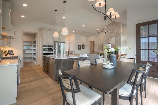 dining area with recessed lighting, a notable chandelier, light wood-style floors, and high vaulted ceiling