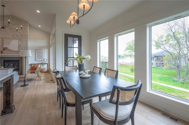 dining area featuring an inviting chandelier, a healthy amount of sunlight, lofted ceiling, and visible vents