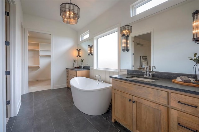 bathroom with a notable chandelier, a sink, a healthy amount of sunlight, and visible vents