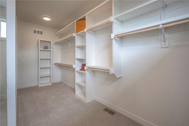 walk in closet featuring visible vents and light carpet