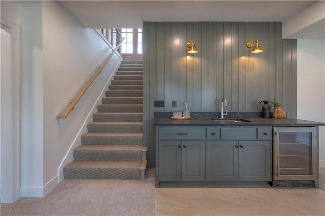 bar with a sink, stairway, baseboards, wine cooler, and wet bar
