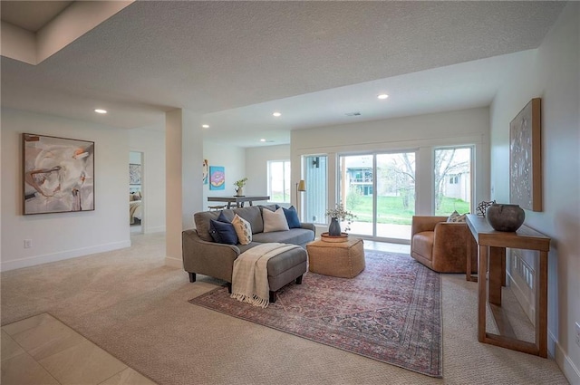 living area featuring a textured ceiling, recessed lighting, baseboards, and carpet floors