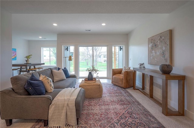 living room with recessed lighting, visible vents, carpet flooring, and baseboards