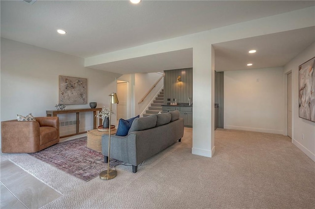 living room featuring baseboards, stairway, light carpet, and recessed lighting