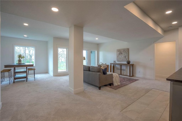 living room with recessed lighting, light colored carpet, and baseboards