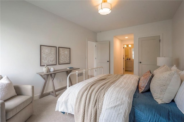 bedroom featuring carpet flooring, ensuite bath, and baseboards