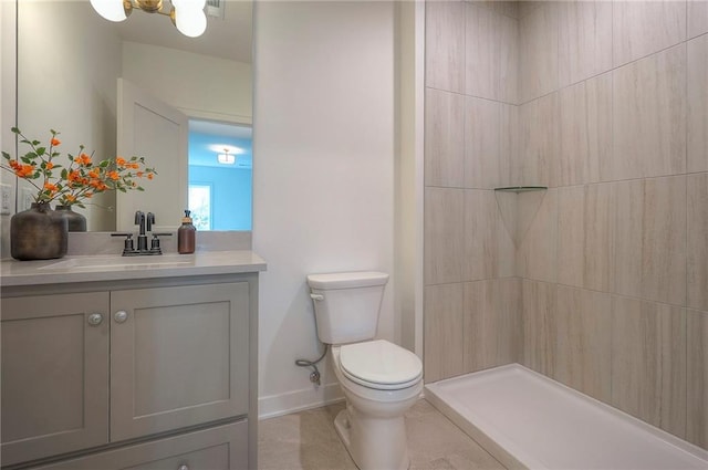 full bath featuring baseboards, a tile shower, toilet, and vanity