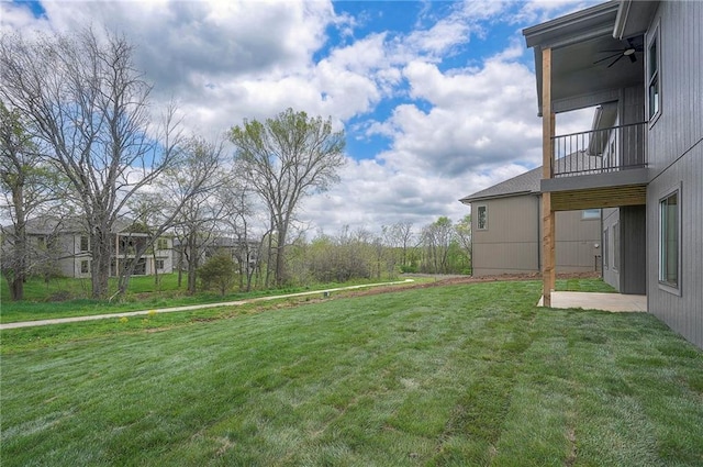 view of yard with ceiling fan and a balcony