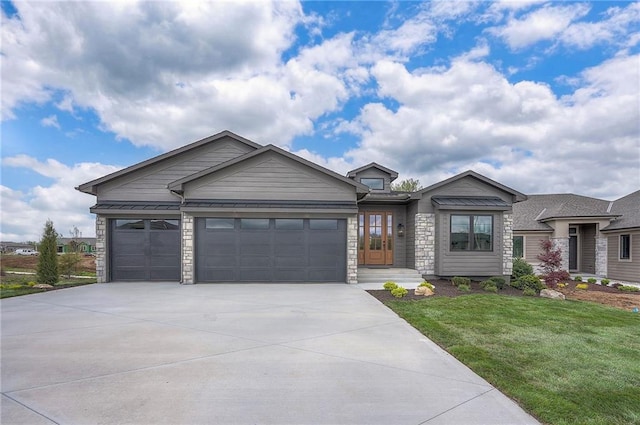 view of front of home featuring concrete driveway, a front lawn, stone siding, and an attached garage