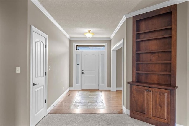 foyer with baseboards, ornamental molding, a textured ceiling, and light carpet