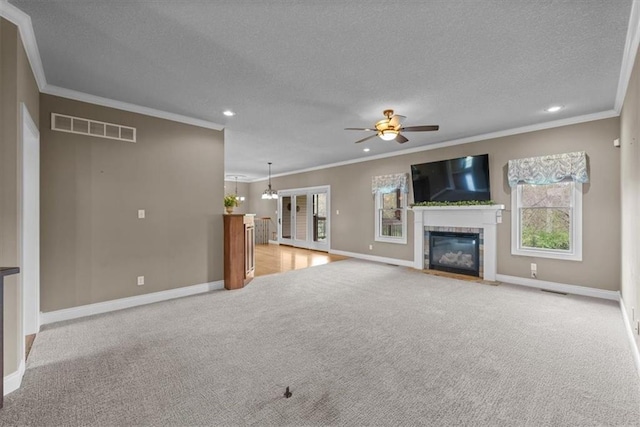 unfurnished living room with a textured ceiling, visible vents, ornamental molding, and baseboards