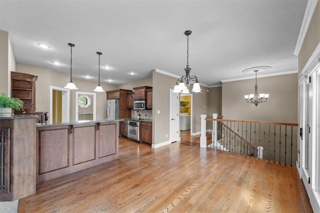 kitchen featuring open shelves, appliances with stainless steel finishes, an inviting chandelier, light wood-style floors, and a peninsula
