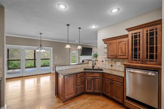 kitchen with a sink, light wood-style floors, dishwasher, a textured ceiling, and a peninsula