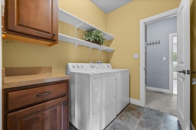 laundry room featuring baseboards, cabinet space, washing machine and dryer, and dark colored carpet