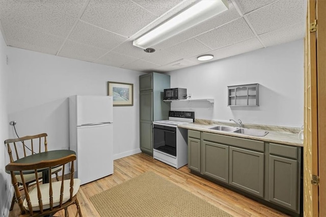 kitchen featuring black microwave, a sink, freestanding refrigerator, electric stove, and a drop ceiling