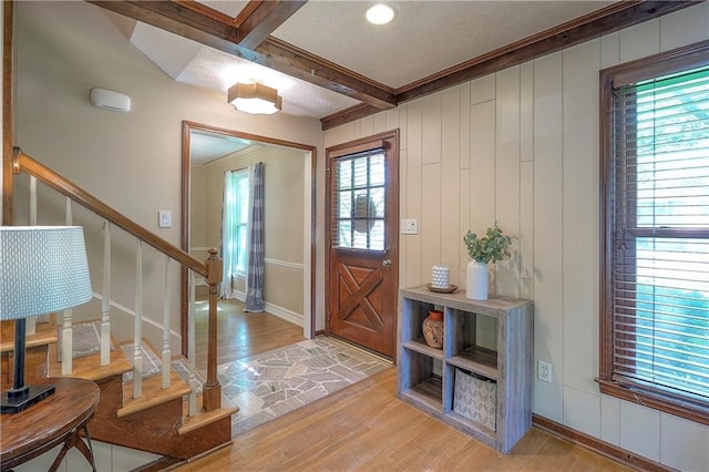 10312 Lamar Ave, Overland Park, KS 66207 - foyer entrance featuring light wood-style floors, beam ceiling, stairs, baseboards, and a decorative wall